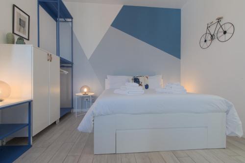 a bedroom with a white bed with a bike on the wall at Sesto Sky Design - Sesto Rondò in Sesto San Giovanni