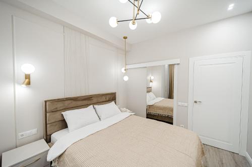 a bedroom with a bed and a chandelier at Eminescu Residence! in Chişinău