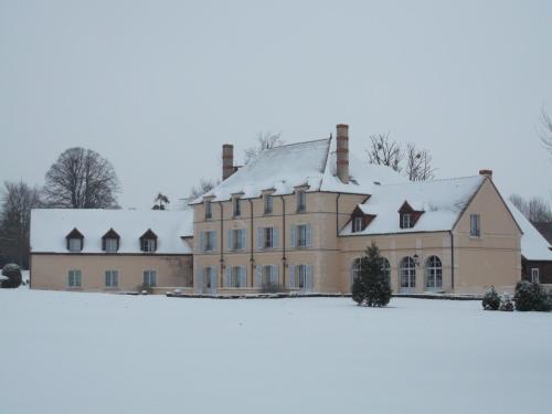 a large house with snow on top of a field at Hôtel Domaine de l'Orangerie in Bonnat