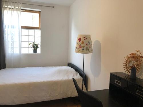 une chambre avec un lit et une table avec une lampe dans l'établissement 2 pieces proche du métro, à Romainville