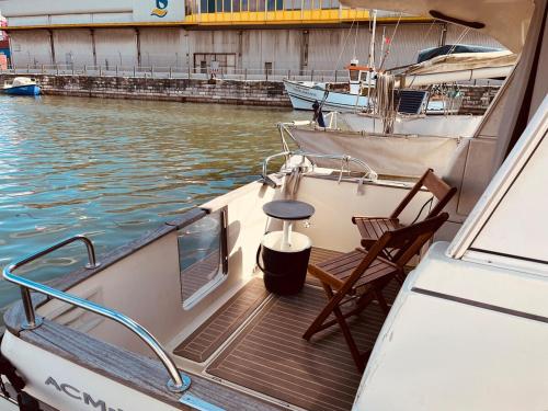 a boat with a table and a chair on the deck at Ero- A floating Escape in Lisbon in Lisbon