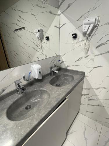 un baño con lavabo y espejo en Mega Hostel, en Almaty