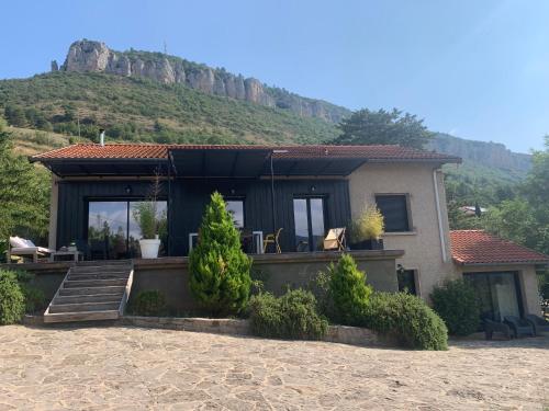 a house with a mountain in the background at Dans la Pouncho d’Agast in Millau