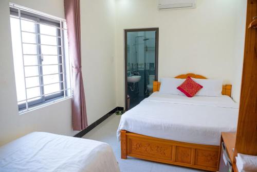 a bedroom with two beds and a mirror at Gold Stone Hoi An Homestay in Hoi An