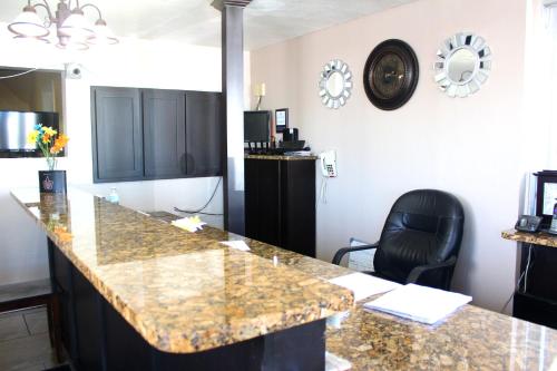 a kitchen with a granite counter top and a black chair at Budget Inn - St. Petersburg in St Petersburg
