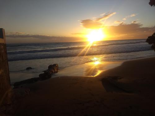 a sunset on the beach with the sun setting at Dragonfly in Treasure Beach