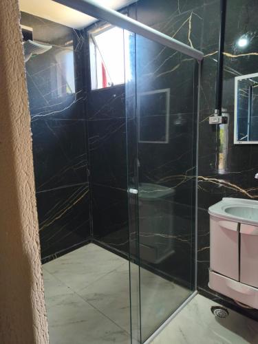 a bathroom with a glass shower with a toilet at Hostel Big Ben in Paranapiacaba