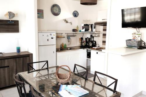 une cuisine avec une table et des chaises en verre dans l'établissement Modern apartment in Val André 50m from the sea, à Pléneuf-Val-André