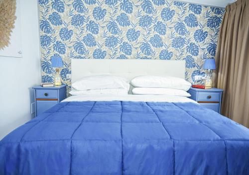 a blue bedroom with a bed with a blue and white wallpaper at Esmeralda Holiday Home in Bracciano