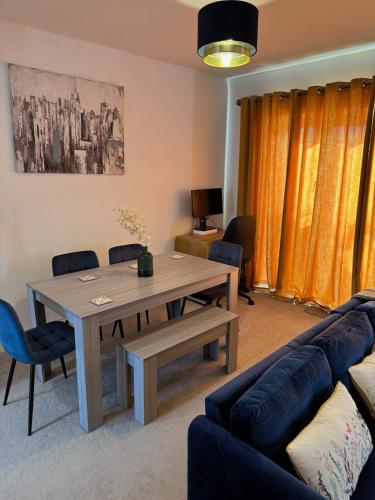 a living room with a table and a couch at Three-bedroom modern family home by the pond with free parking in Warfield