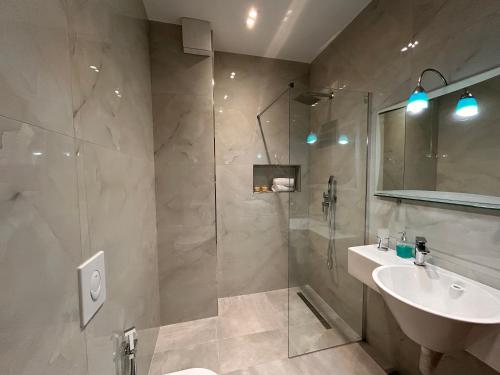 une salle de bain avec douche et lavabo dans l'établissement Elisabeth Apartments 3, à Saranda