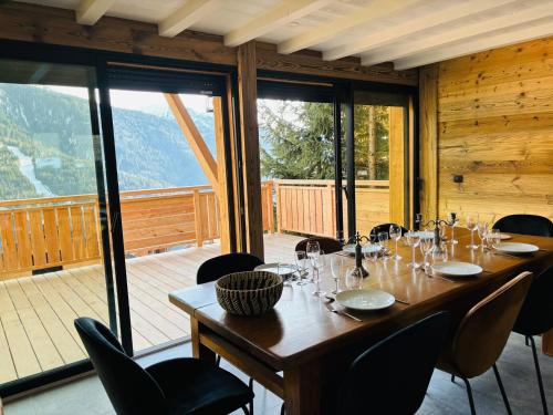 une salle à manger avec une table et des chaises et un balcon dans l'établissement VAUJANYLOCATIONS - Chalet Sagha, à Vaujany