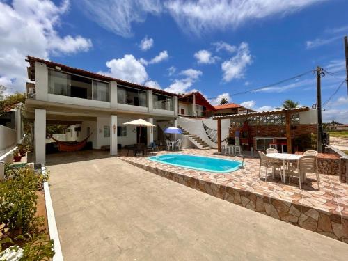 a house with a swimming pool and a patio at Martinelli Residence Beira Mar I e II in Itamaracá