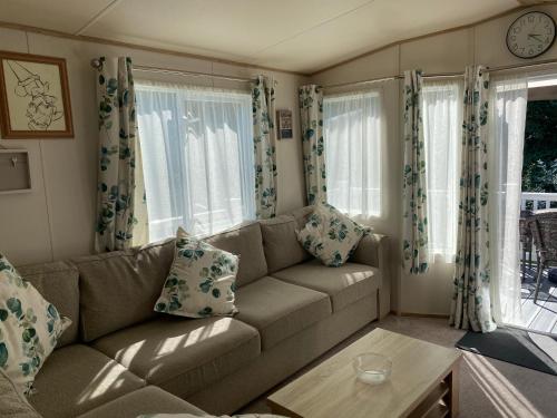 a living room with a couch and some windows at 2 Bed Static Caravan sleeps 6 Saxmunham in Saxmundham
