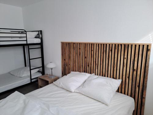 une chambre avec un lit avec une tête de lit en bois dans l'établissement Appartement Berck sur Mer, à Berck-sur-Mer