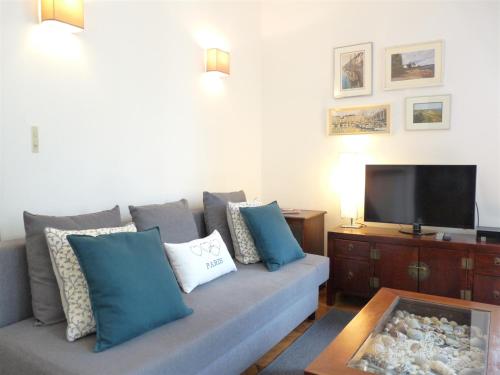 - un salon avec un canapé, des oreillers et une télévision dans l'établissement Le Alesia, à Paris