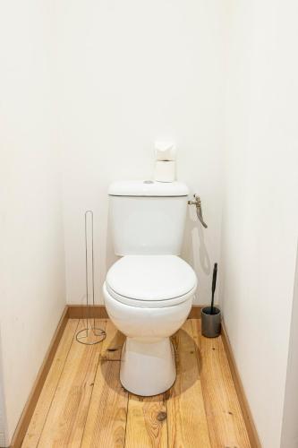 a white toilet in a bathroom with a wooden floor at Grand Central Suites - 4 Chambres Premium in Pau