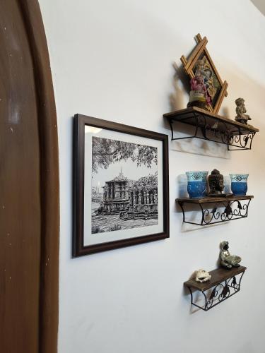 a picture hanging on a wall with two shelves at Nama-Stay - An escape villa in Ooty