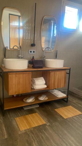 une salle de bain avec deux lavabos et deux miroirs dans l'établissement Fabulous big Studio with balcon Arc of Triumph, à Paris