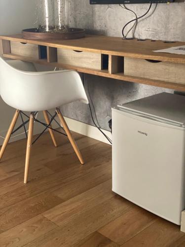 une chaise blanche à côté d'un bureau et d'une table dans l'établissement Fabulous big Studio with balcon Arc of Triumph, à Paris