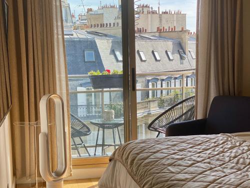 une chambre avec un lit et une fenêtre avec vue dans l'établissement Fabulous big Studio with balcon Arc of Triumph, à Paris