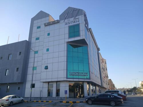 un bâtiment avec des voitures garées dans un parking dans l'établissement XYZ Hotel Qurtoba, à Riyad
