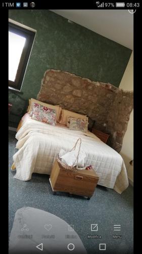 a bedroom with a large bed with a stone wall at B&B Home Holiday Villa delle Acacie agriturismo in Sala Consilina