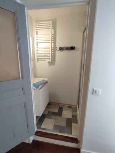 un couloir avec une porte menant à une salle de bains. dans l'établissement APPARTEMENT QUARTIER CATHEDRALE, à Blois
