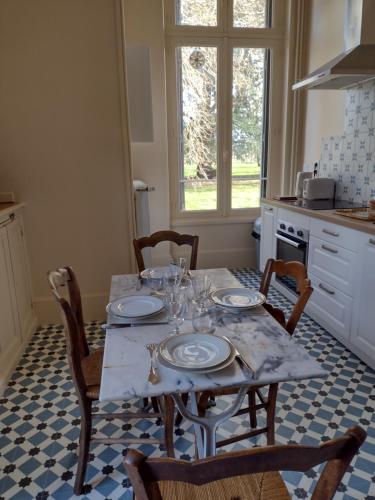 a kitchen with a table with plates on it at Castle Of Saint Germain Des Rives in Saint-Germain-des-Rives