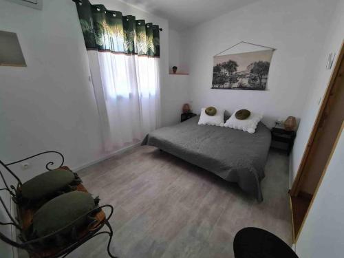 une chambre avec un lit et une grande fenêtre dans l'établissement maisonnette adossée a un mas 2 chambres, à Orange