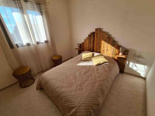 une chambre avec un grand lit et une fenêtre dans l'établissement maisonnette adossée a un mas 2 chambres, à Orange