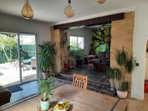 un salon avec une table et des plantes en pot dans l'établissement Villa entre centre ville et mer, à Montpellier