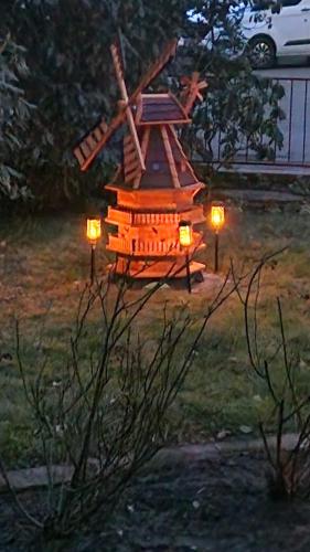 a small wooden windmill in a yard at night at Am Wäldchen in Hechthausen