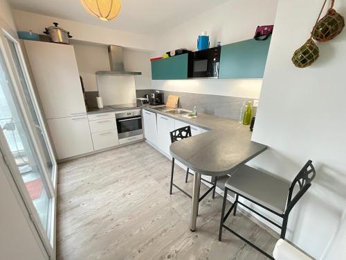une petite cuisine avec une table et des chaises. dans l'établissement De Monzie 6pers Tv Wifi 2, à Nantes