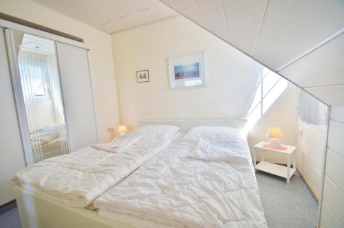 ein weißes Bett in einem Zimmer mit Fenster in der Unterkunft Müller 4 - a10797 in Dahme