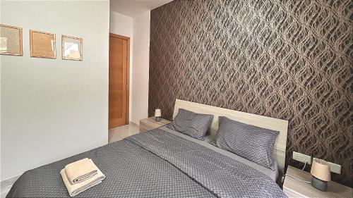una camera con un letto a scomparsa con motivi geometrici di Arzella Apartments Xlendi Stylish Stay Near Beach Local Eats a Xlendi