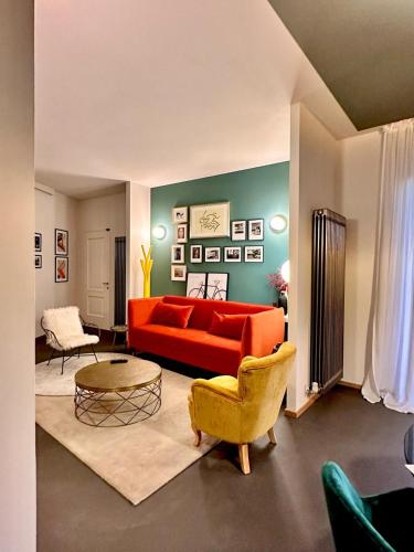 a living room with a red couch and chairs at Dimora Roè in Monticello d'Alba