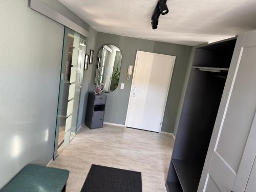 a hallway with a white door and a mirror at ErzgebirgsLoft in Annaberg-Buchholz