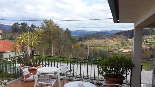 a balcony with tables and chairs and a view at hostel do Ermal in Vieira do Minho