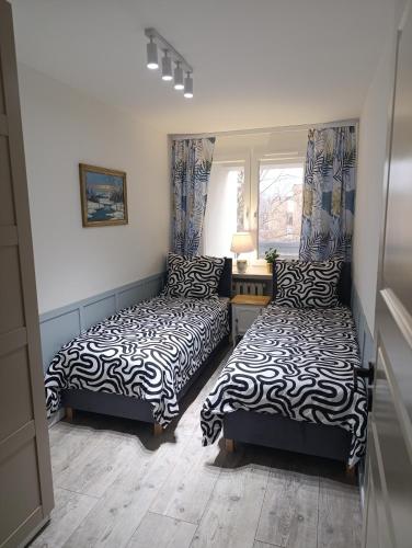 a bedroom with two beds and a window at APARTAMENT "Opawska Przystań" in Głuchołazy