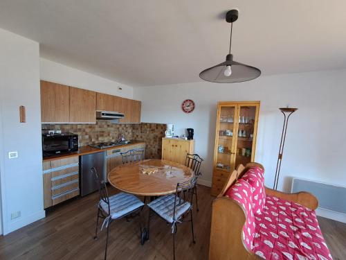 a kitchen with a table and chairs in a room at Appartement résidence Les Dryades avec vue montagne in Gérardmer