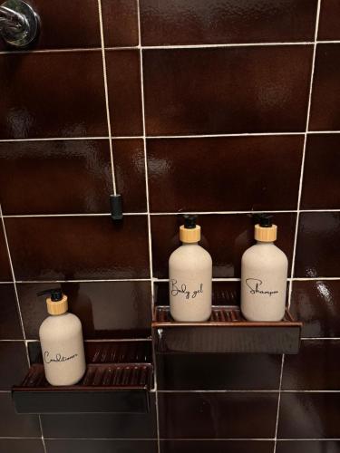 three white bottles sitting on a shelf in a bathroom at La Limonaia di Vanna in Impruneta