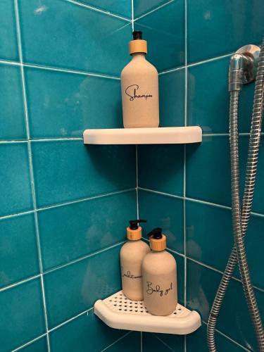 three white bottles on shelves in a bathroom at La Limonaia di Vanna in Impruneta