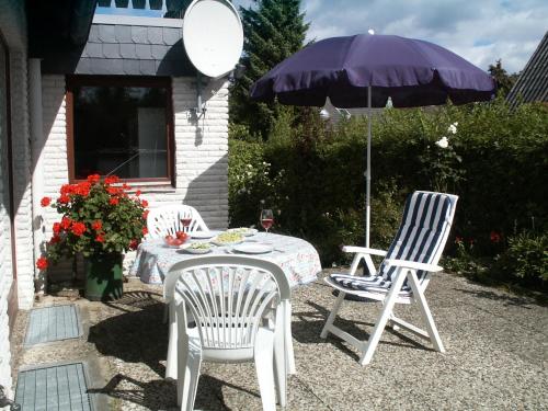 a table and two chairs and an umbrella at Ferienwohnung Wöllner Nr 1 in Maasholm