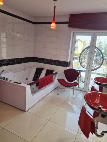 a room with a tub and a table and chairs at Apartament Nina in Skoczów