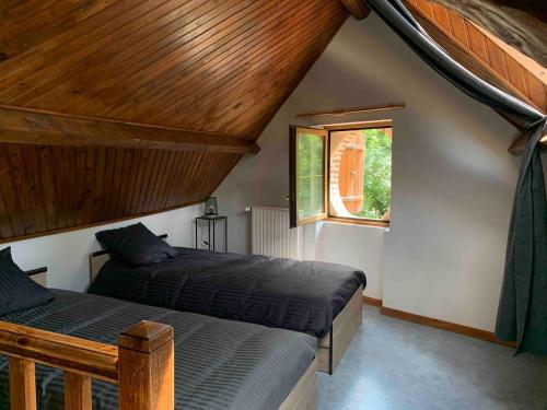 a bedroom with two beds and a window at La MAISON d'AUBUSSON in Aubusson