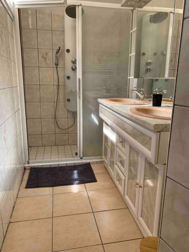 La salle de bains est pourvue d'une douche, de 2 lavabos et d'un miroir. dans l'établissement La MAISON d'AUBUSSON, à Aubusson