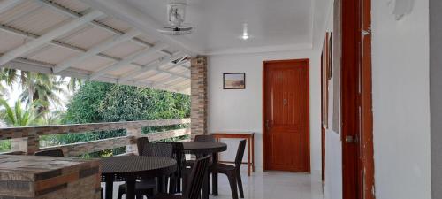 a porch with a table and chairs and a door at Chilly Beach Resort Palawan in Aborlan