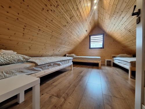 two beds in a room with a wooden ceiling at Chyžky v Runine in Runina
