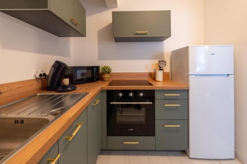 La cuisine est équipée d'un réfrigérateur et d'un évier. dans l'établissement Appartement 2 à 4 personnes Calais, à Calais